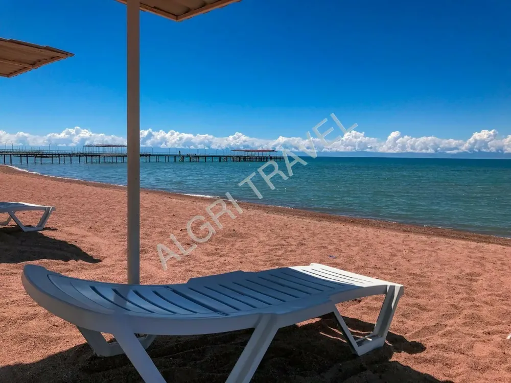 Пляж оборудован зонтами и шезлонгами