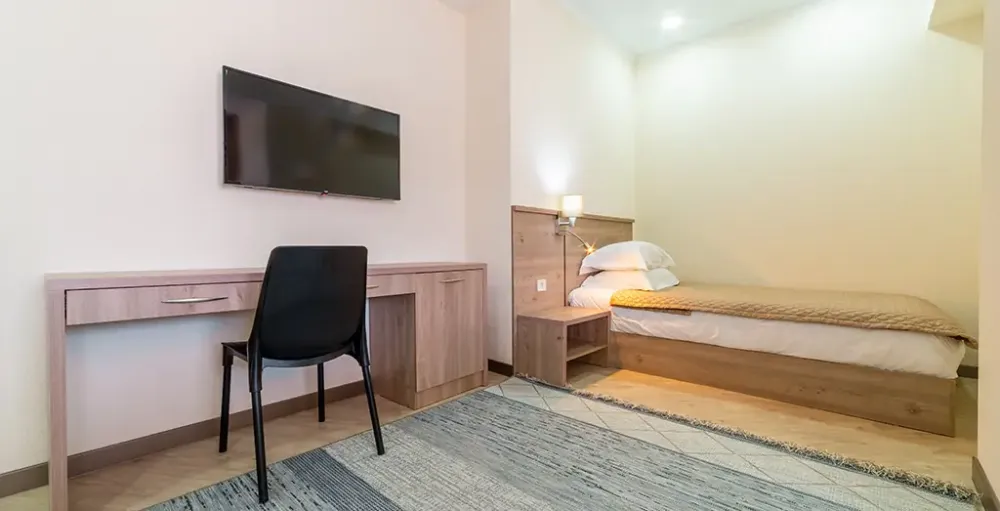 Рабочая зона и односпальная кровать в номере Адель