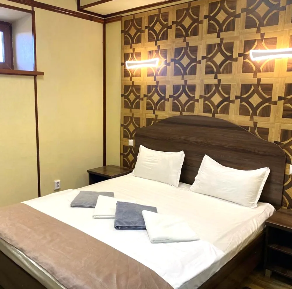 Кровать и небольшое окно в номере